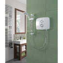 Modern bathroom with shower setup, including a shower head and control panel on a green tiled wall.